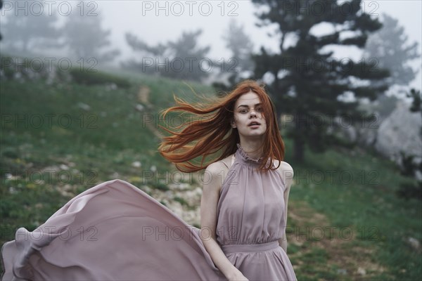 Wind blowing hair of Caucasian woman in field