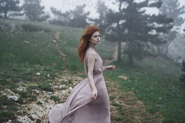 Wind blowing hair of Caucasian woman in field