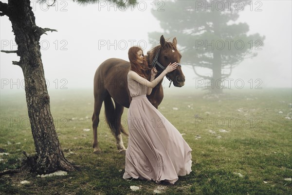 Caucasian woman petting horse