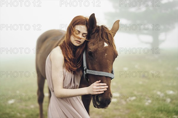 Caucasian woman petting horse