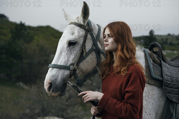 Caucasian woman holding rein of horse