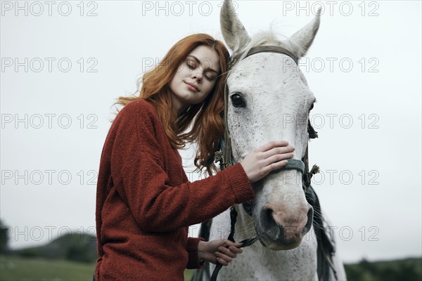 Caucasian woman petting horse