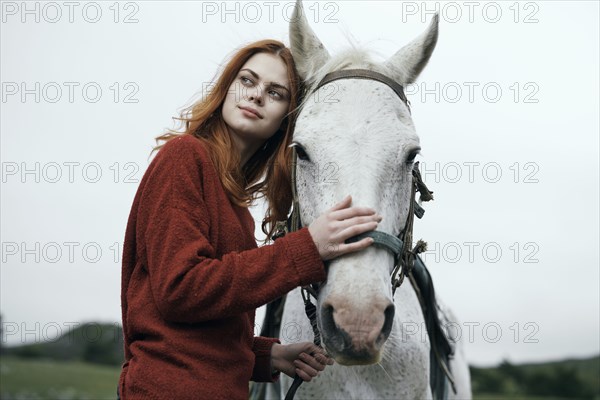 Caucasian woman petting horse