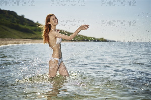 Caucasian woman splashing in ocean