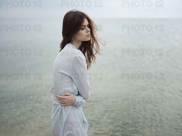 Troubled Caucasian woman standing near ocean