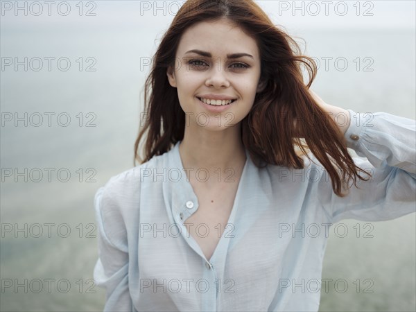 Smiling Caucasian woman standing near ocean