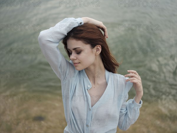 Smiling Caucasian woman standing near ocean