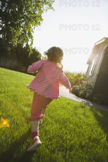 Back of girl running in back yard