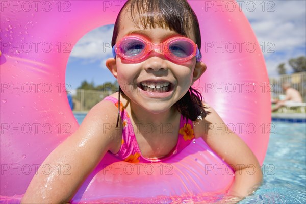 Portrait of girl in swimming pool wearing goggles