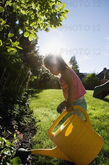 Girl watering plants with watering can