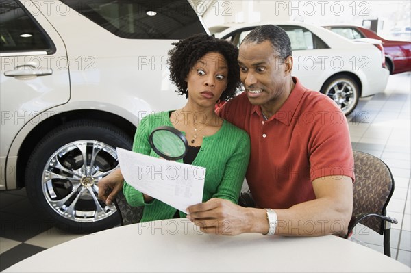 Couple reading the fine print with a magnifying glass