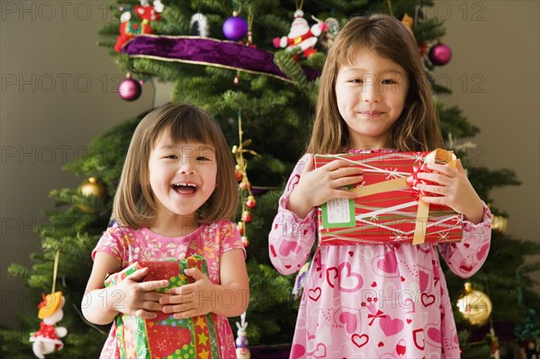 Two young sisters with Christmas presents