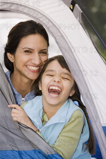 Hispanic mother and daughter laughing in tent