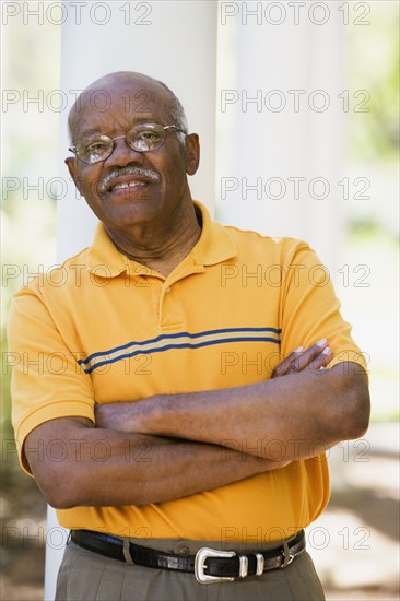 Senior African American man leaning on post outdoors