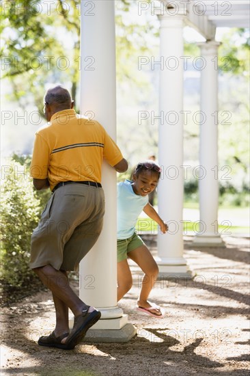 African American grandfather and granddaughter playing outdoors