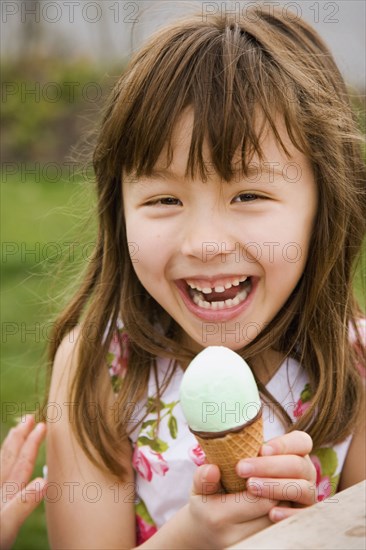 Young Asian girl eating ice cream cone