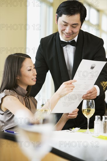 Asian businesswoman ordering meal in restaurant