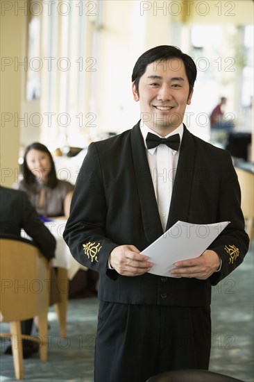 Asian male waiter at upscale restaurant