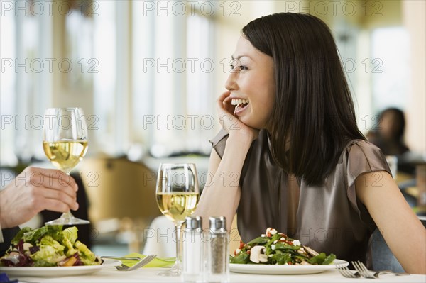 Asian woman laughing at restaurant