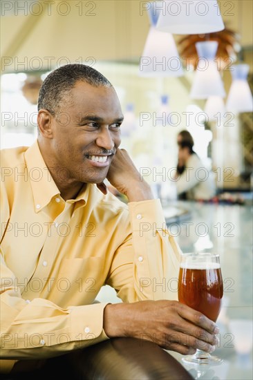 African American man with drink at bar