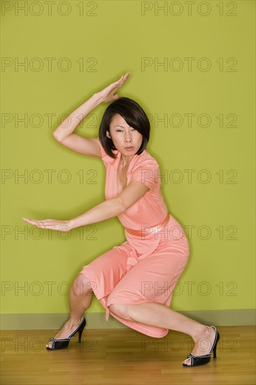 Asian woman in dress doing martial arts move