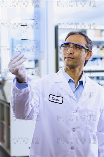 Indian male scientist looking at DNA film