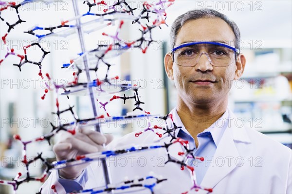 Indian male scientist holding DNA model