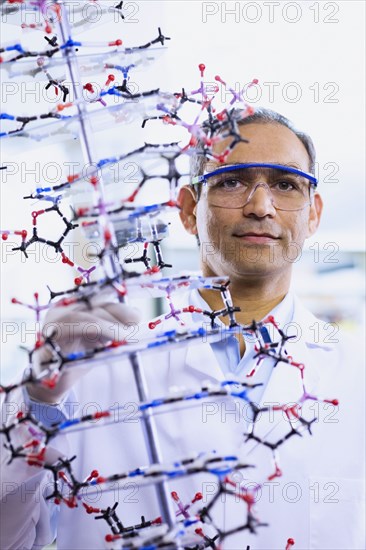 Indian male scientist holding DNA model