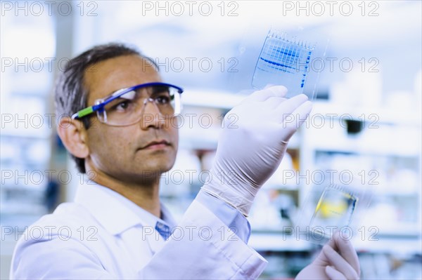 Indian male scientist looking at DNA film