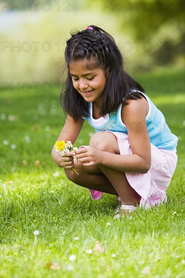 Hispanic girl picking flowers