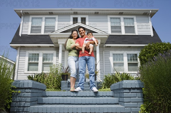 Portrait of Hispanic family in front of house