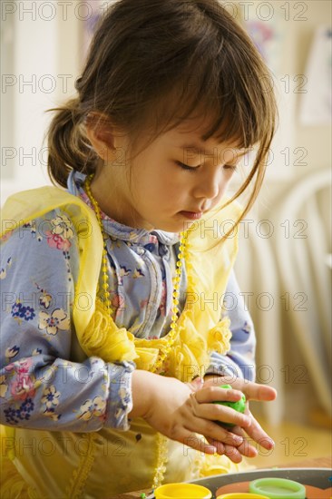 Asian girl playing with clay
