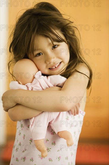 Asian girl hugging doll