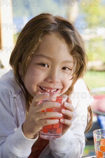 Asian girl holding glass of water