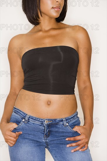 Studio shot of young Hispanic woman in strapless top and jeans