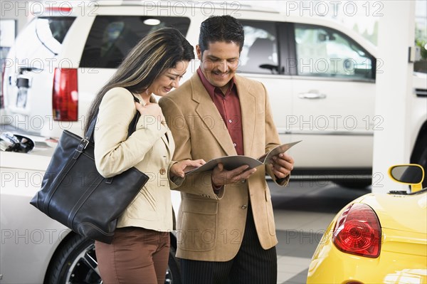 Hispanic couple at car dealership