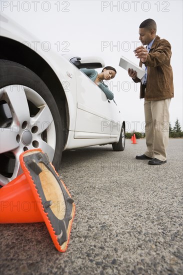 African teenager running over traffic cone at drivers test