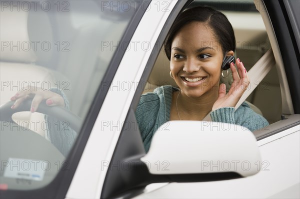 African woman using hands free device in car