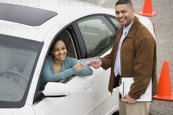 African teenager receiving drivers test certificate