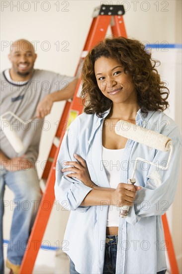 African woman holding paint roller