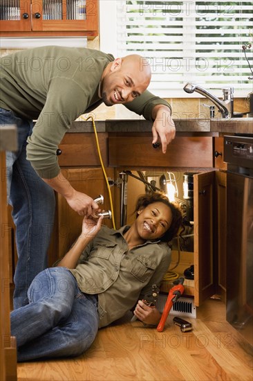 African couple installing kitchen sink