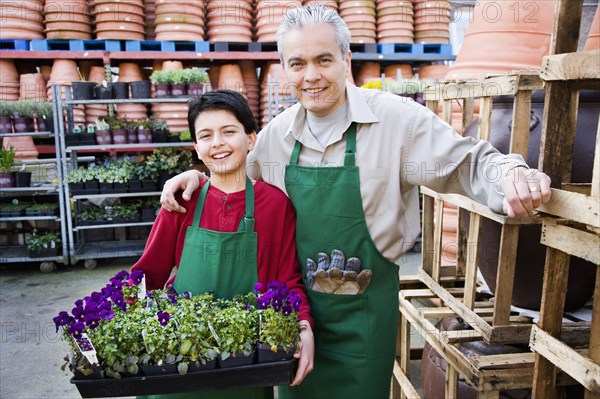 Hispanic father and son working at garden center