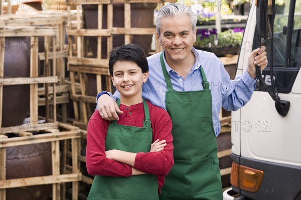 Hispanic father and son working at garden center