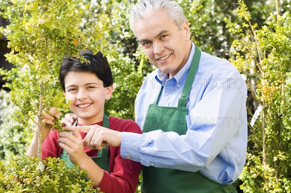 Hispanic father and son working at garden center