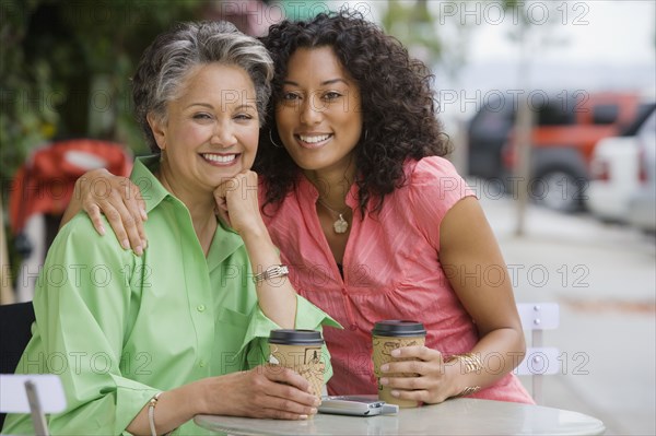 African American mother and adult daughter hugging