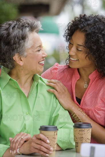 African American mother and adult daughter smiling at each other