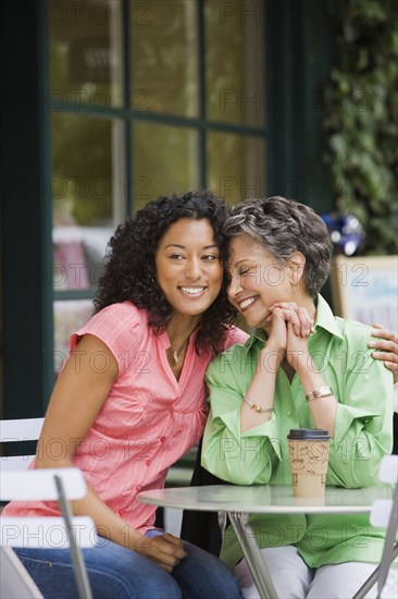 African American mother and adult daughter hugging