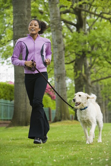 African American woman jogging with dog