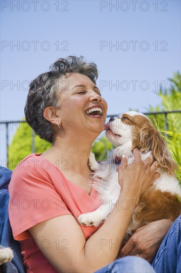 Senior African American woman hugging dog