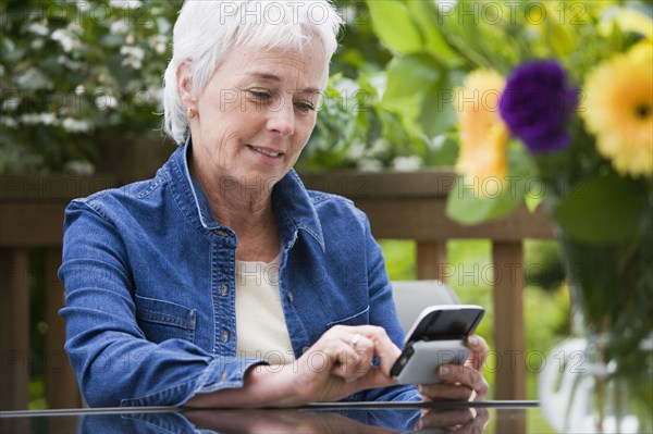 Senior woman using electronic organizer outdoors